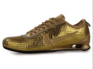 Photo of golden Nike trainers on a white background