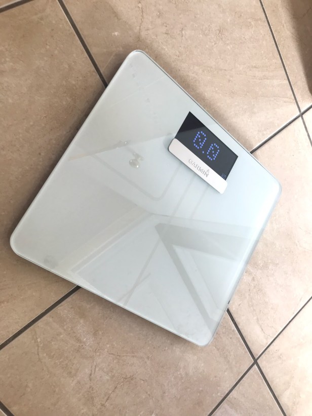 Photo of a Garmin weighing scale on a bathroom floor