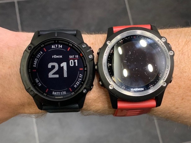 Two Garmin Fenix watches side-by-side on a wrist